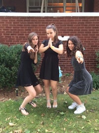 three girls in black dresses posing for a picture