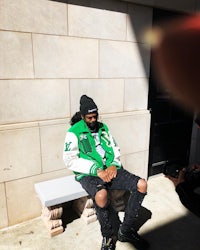 a man sitting on a bench in front of a building
