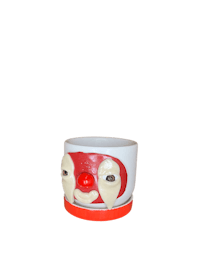 a clown face shaped cup on a black background