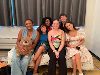 a group of people sitting on a couch with a teddy bear