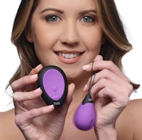 a woman holding a purple and black vibrator