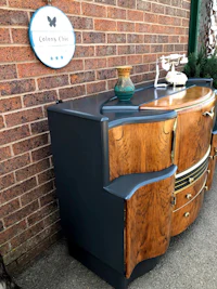 a black and wood sideboard with a dog sitting on it