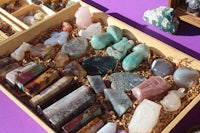 a wooden box filled with a variety of stones