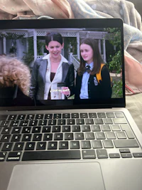 a laptop with a screen showing a woman and a man