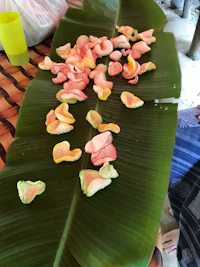 a banana leaf with a lot of fruit on it