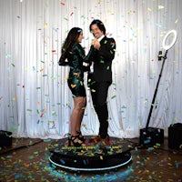 a man and woman standing in front of confetti