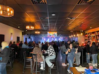 a crowd of people at a bar in a restaurant