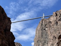 a bridge over a canyon with a blue sky in the background