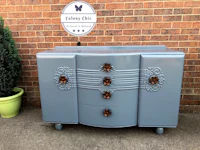 a blue dresser with a flower on it