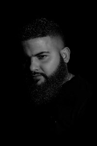 a black and white photo of a man with a beard