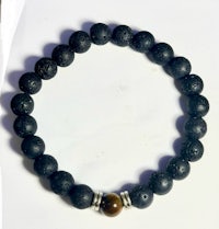 a black lava bracelet with a tiger eye bead