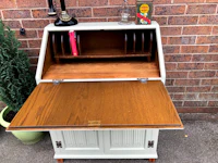 a small wooden desk with a bookcase on top
