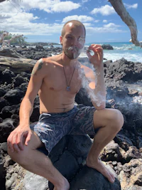 a man smoking a cigarette on the beach