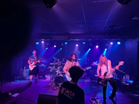 a group of people playing music on stage in a dark room