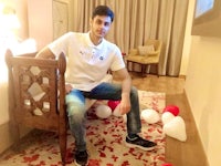a man sitting on a chair in a room with balloons