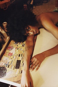 a woman laying on a table with a painting on it