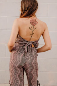 the back of a woman with a rose tattoo on her back