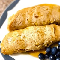 two pancakes on a plate with blueberries