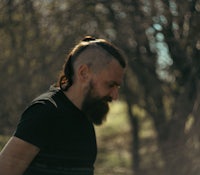 a man with a beard riding a skateboard