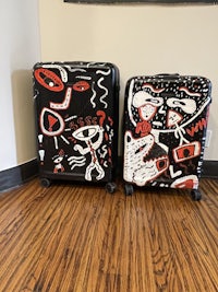 two suitcases with designs on them are sitting on a floor