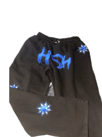a pair of black sweatpants with blue stars on them