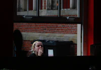 a woman sitting at a table looking out a window
