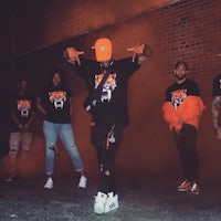 a group of people in orange t - shirts standing in front of smoke