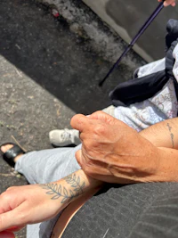 a woman with a tattoo on her arm holding a cane
