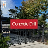 a sign that says concrete drill in front of a fence