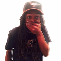 a man with dreadlocks covering his mouth
