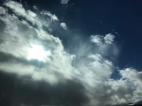 the sun shines through a cloudy sky