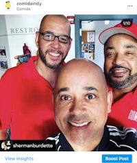 three men in red shirts are posing for a photo