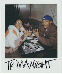 a man and woman sitting at a table with a drink