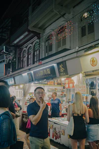 a group of people standing in front of a market at night