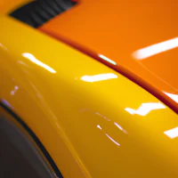 a close up of an orange and black car