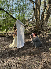 two women taking pictures in the woods