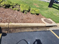 a man cleaning a manhole in a parking lot