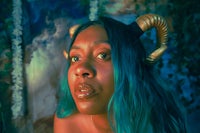 a woman with blue hair and horns on her head