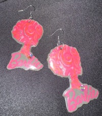 a pair of pink earrings with the word barbie on them