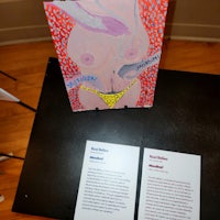 two pieces of art on a table next to each other
