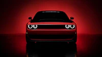 the front end of a red dodge demon in a dark room