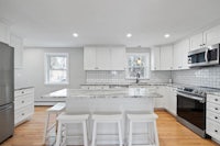 a kitchen with white cabinets and stainless steel appliances