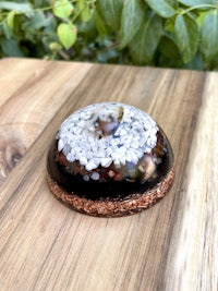 a small terrarium with black and white pebbles on a wooden table