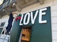a man is putting up a sign for love