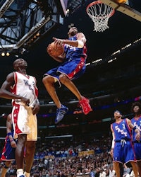 a basketball player dunks the ball during a game