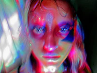 a photo of a woman with colorful lights on her face