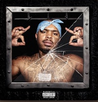 a man with tattoos and a bandana in front of a broken window