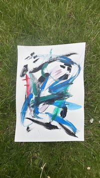 a piece of paper with blue and black paint on it