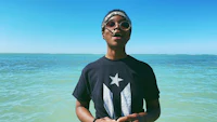 a young man in a black shirt standing in the ocean
