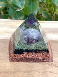 an amethyst pyramid on a wooden table